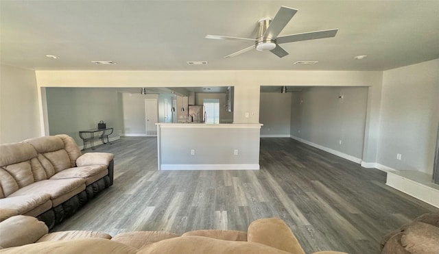 living area featuring baseboards, ceiling fan, dark wood finished floors, and visible vents