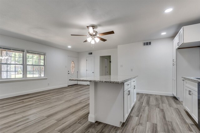 kitchen with light hardwood / wood-style floors, light stone countertops, ceiling fan, and white cabinets