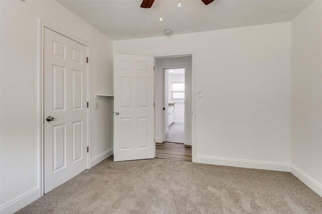 unfurnished bedroom with ceiling fan and light carpet