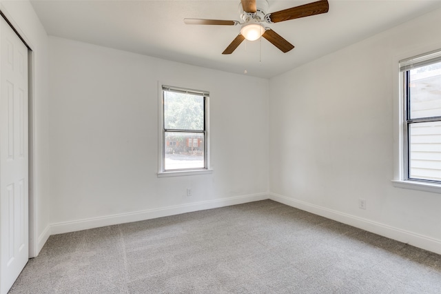 unfurnished bedroom featuring multiple windows, carpet flooring, and ceiling fan