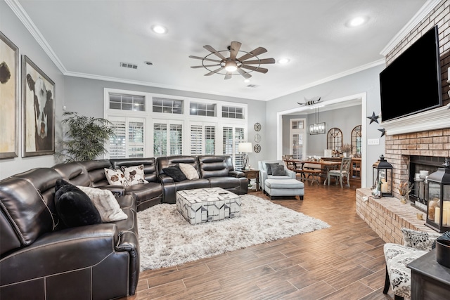 living room featuring ornamental molding, a fireplace, ceiling fan, and hardwood / wood-style flooring