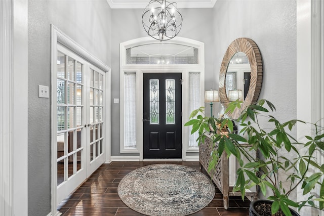 entrance foyer featuring an inviting chandelier, dark hardwood / wood-style flooring, and ornamental molding