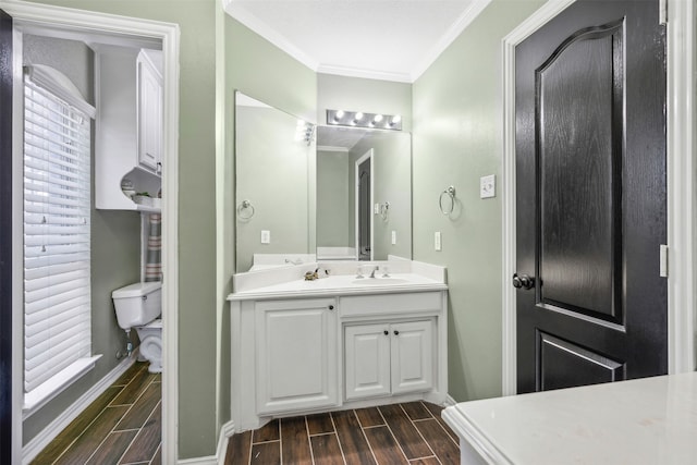 bathroom featuring hardwood / wood-style flooring, crown molding, toilet, and vanity