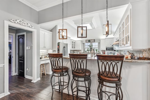 kitchen with white cabinets, backsplash, dark hardwood / wood-style flooring, stainless steel appliances, and stone counters