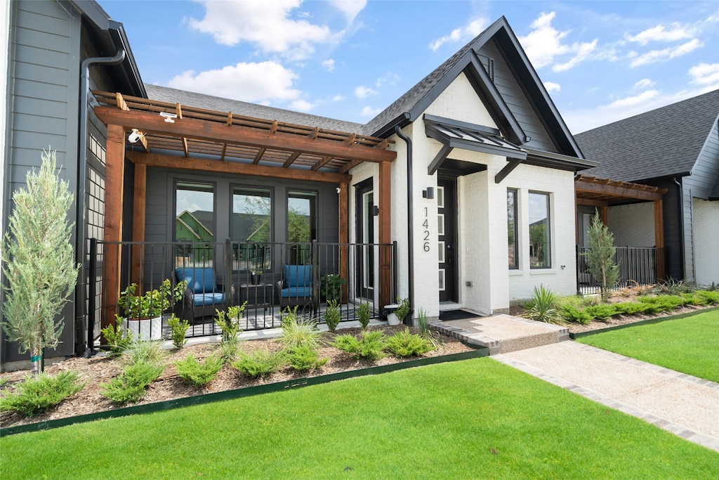 view of front of property featuring a front yard and a pergola