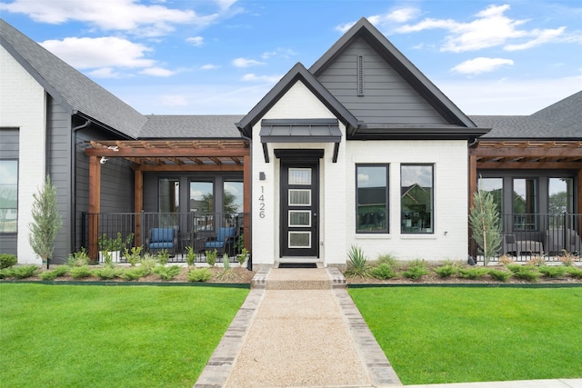 view of front facade featuring a pergola and a front lawn