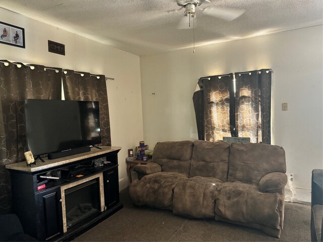 living room featuring a textured ceiling, dark colored carpet, and ceiling fan