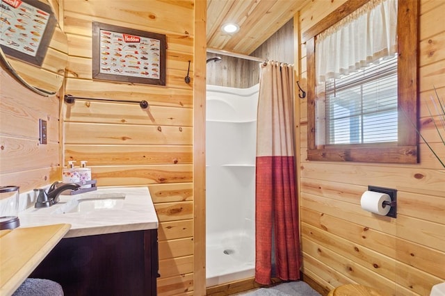 bathroom featuring wood walls, a shower stall, and vanity