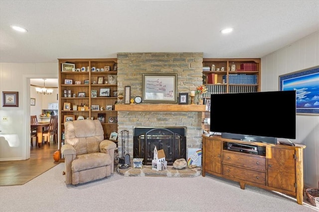 living room featuring a large fireplace, carpet floors, recessed lighting, and a notable chandelier