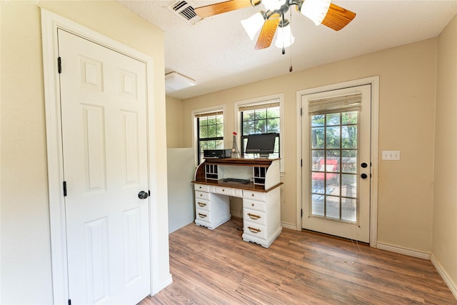 home office featuring ceiling fan, hardwood / wood-style floors, and a textured ceiling