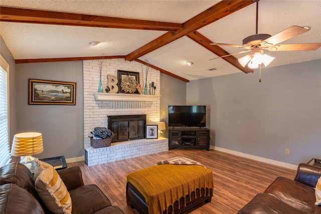 living room with vaulted ceiling with beams, a fireplace, a textured ceiling, and wood-type flooring