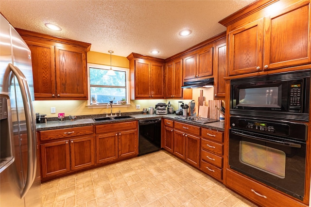 kitchen with sink, decorative light fixtures, black appliances, and dark stone counters