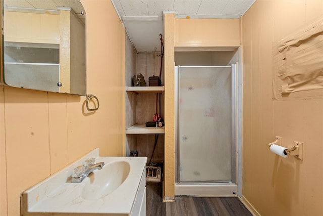 bathroom with a shower with shower door, vanity, and hardwood / wood-style floors