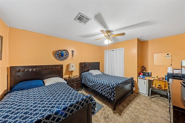 carpeted bedroom featuring ceiling fan and a closet