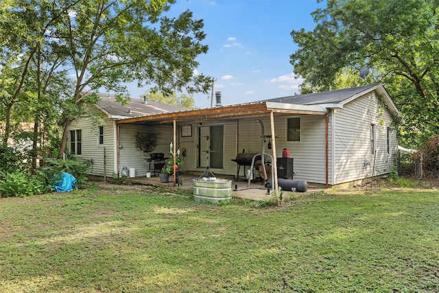 rear view of house featuring a patio area and a lawn