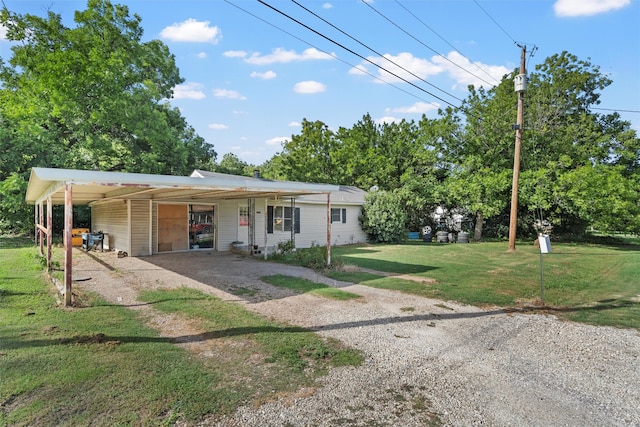 rear view of property featuring a carport and a lawn