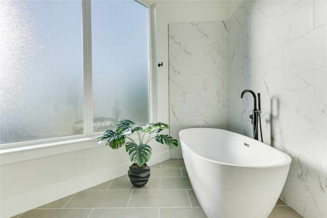 bathroom with tile patterned floors and a tub