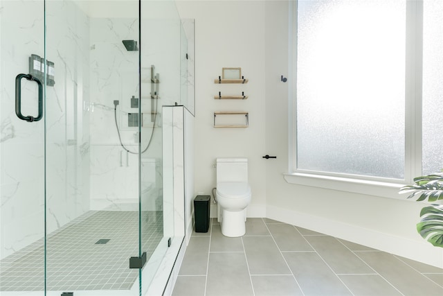 bathroom featuring a shower with shower door, toilet, and tile patterned floors