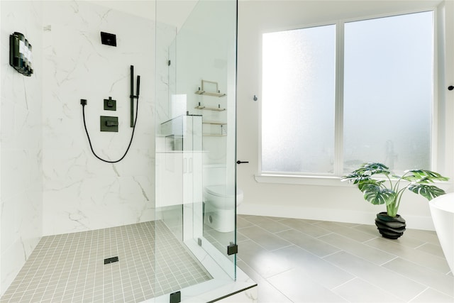 bathroom featuring tile patterned floors, a shower with shower door, and toilet