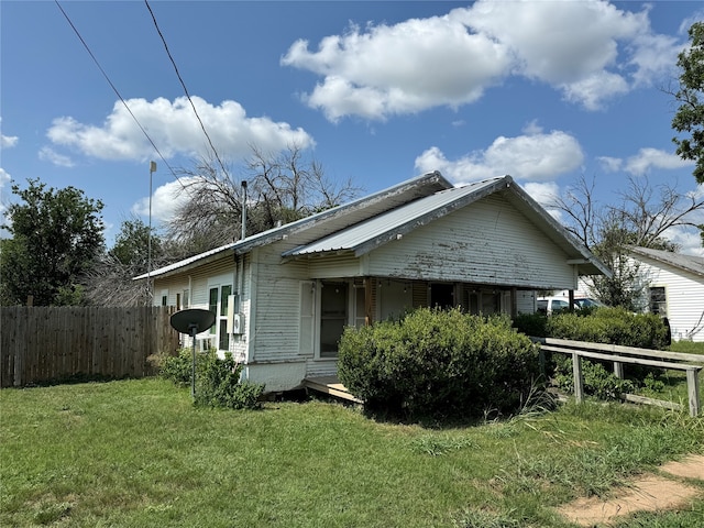 view of side of home with a yard