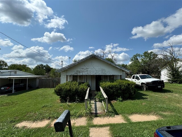 exterior space with a carport and a front lawn