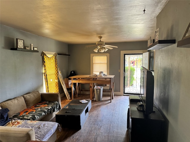 living room with a textured ceiling and ceiling fan