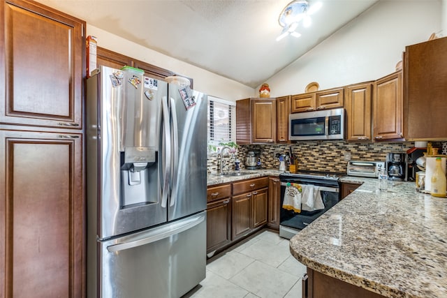 kitchen with tasteful backsplash, light tile patterned floors, stainless steel appliances, vaulted ceiling, and sink