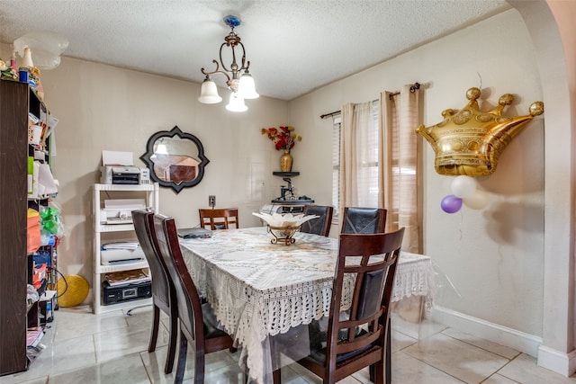 dining room featuring light tile patterned floors and a textured ceiling