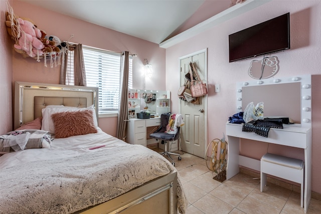 tiled bedroom featuring vaulted ceiling