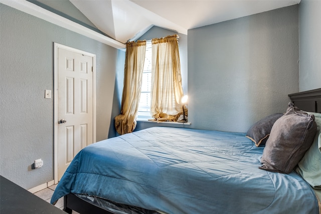 tiled bedroom with lofted ceiling