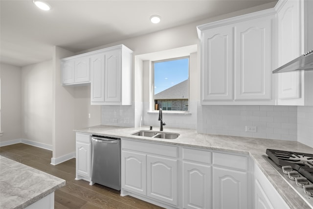 kitchen featuring appliances with stainless steel finishes, backsplash, sink, dark hardwood / wood-style floors, and white cabinetry