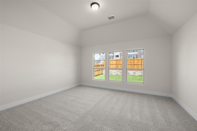 empty room featuring carpet and vaulted ceiling