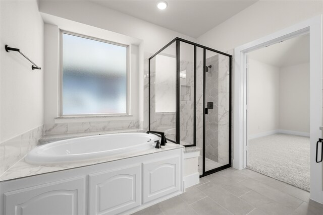 bathroom with tile patterned floors and independent shower and bath