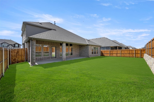 rear view of house featuring a patio area and a yard