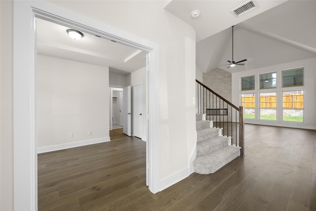 stairway with ceiling fan, high vaulted ceiling, and hardwood / wood-style flooring