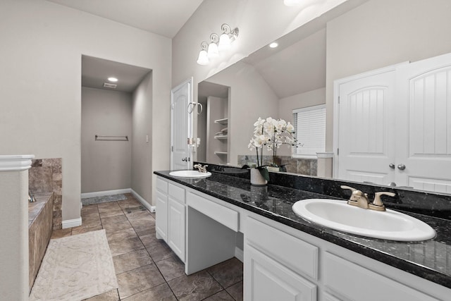 bathroom featuring baseboards, a sink, a bath, and double vanity