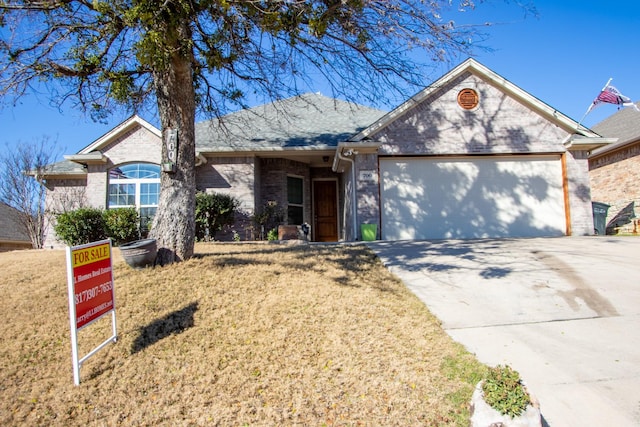 ranch-style house with driveway, brick siding, a front lawn, and an attached garage