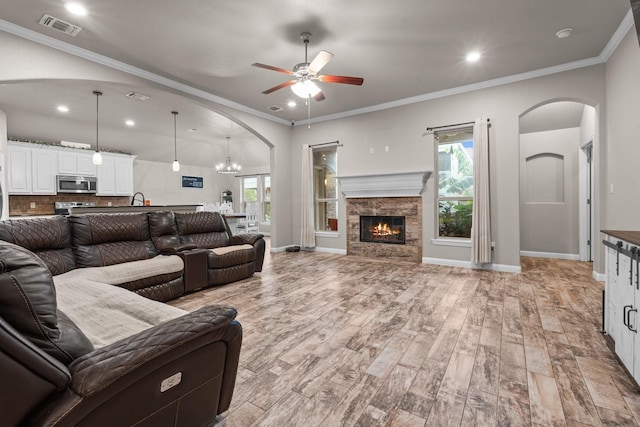 living room featuring light wood-type flooring, plenty of natural light, visible vents, and crown molding