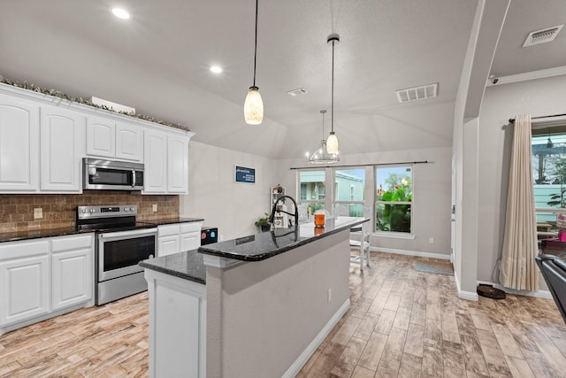 kitchen featuring appliances with stainless steel finishes, visible vents, backsplash, and dark stone countertops