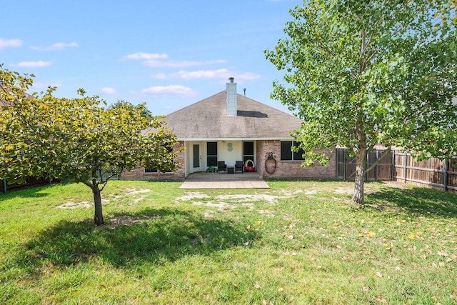 rear view of property with brick siding, roof with shingles, and a chimney