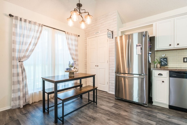 kitchen with decorative backsplash, appliances with stainless steel finishes, dark wood-type flooring, pendant lighting, and white cabinetry