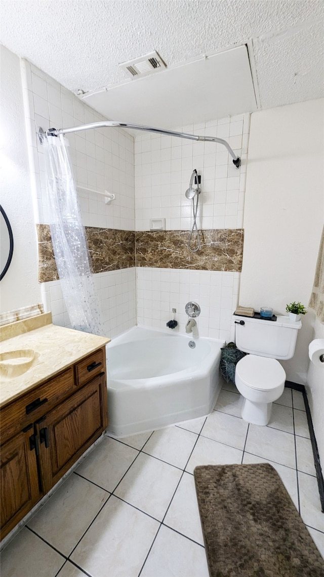 full bathroom with tile patterned floors, toilet, shower / tub combo with curtain, vanity, and a textured ceiling