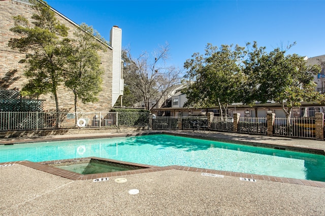 view of swimming pool with a community hot tub