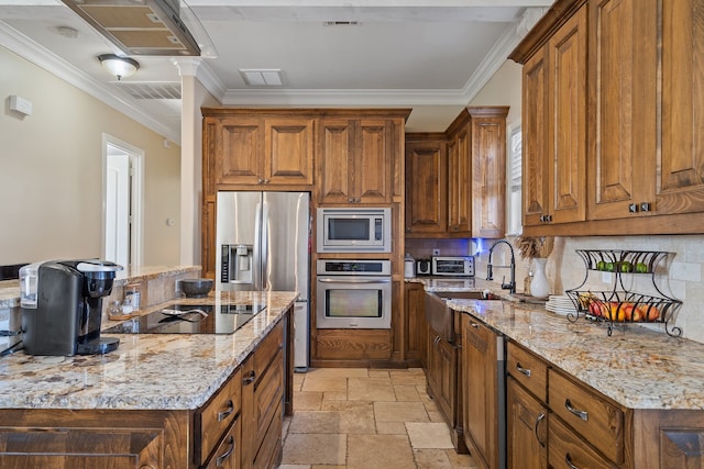 kitchen featuring light stone counters, sink, backsplash, appliances with stainless steel finishes, and crown molding