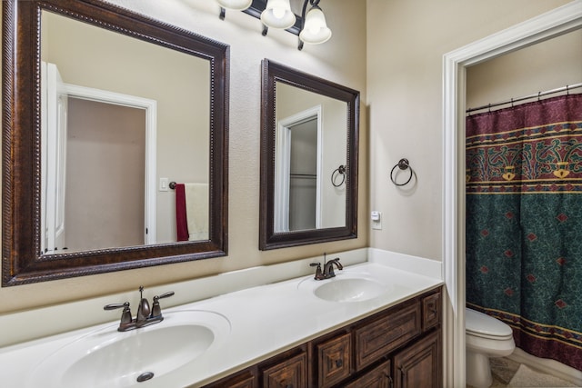 bathroom with tile patterned floors, toilet, and dual bowl vanity