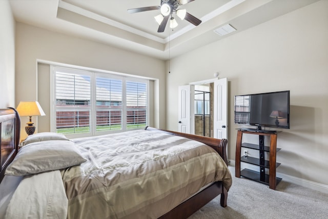 bedroom featuring carpet floors, ceiling fan, and a raised ceiling