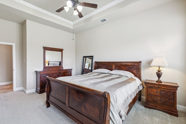 bedroom featuring ceiling fan, a tray ceiling, and light colored carpet