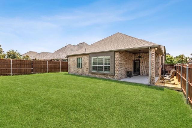 rear view of property featuring a patio and a lawn