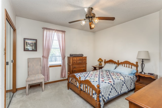 carpeted bedroom featuring a textured ceiling, a closet, and ceiling fan