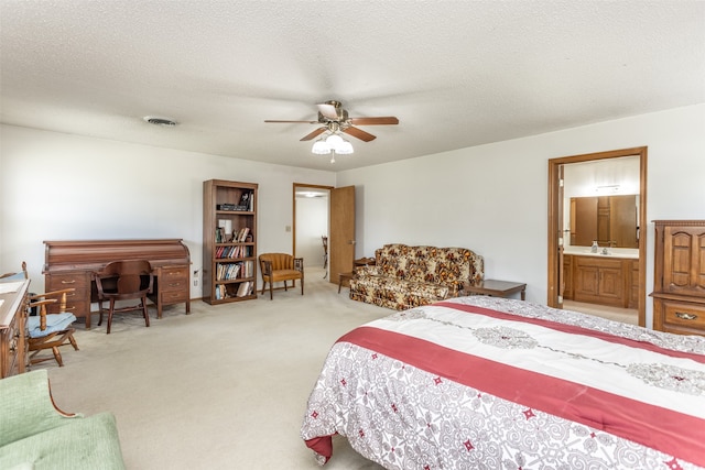 carpeted bedroom with a textured ceiling, connected bathroom, sink, and ceiling fan